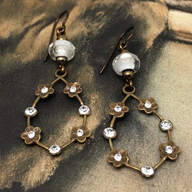 Boucles d'oreilles vintage composées de pendentifs en laiton doré ornées de petites fleurs serties de cristaux blancs. Bijoux uniques de créateur.