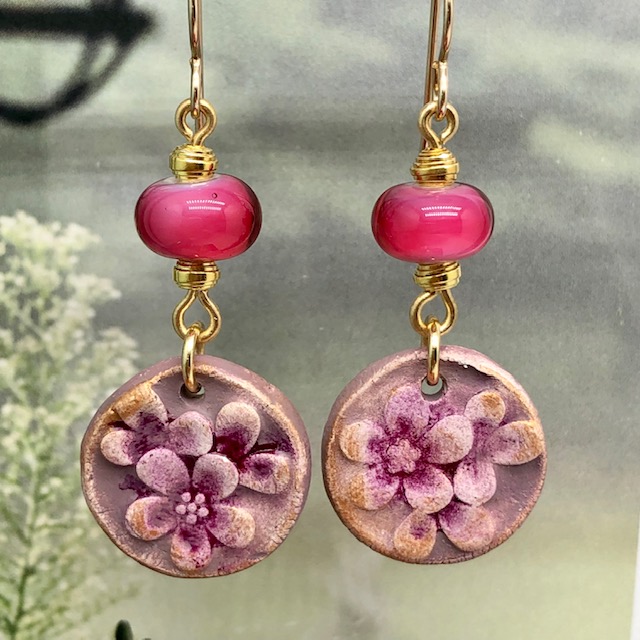 Boucles d'oreilles bohème fleurs roses composées de pendentifs artisanaux en céramique et de perles en verre filé. Pièces uniques.