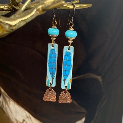 Boucles d'oreilles bohème plumes bleues composées de pendentifs artisanaux en cuivre illustré et de perles lampwork. Pièces uniques.