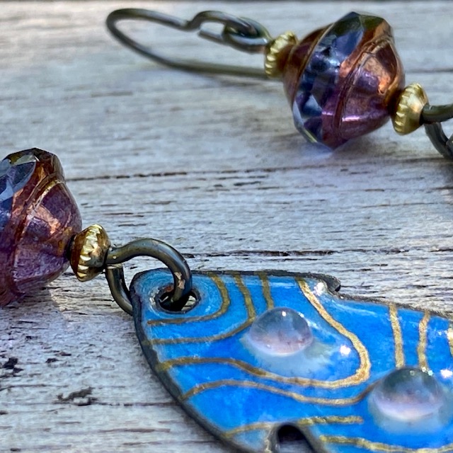 Boucles d'oreilles composées de pendentifs artisanaux en laiton émaillé et de perles en verre de Bohême. Crochets d'oreilles en niobium. Pièces uniques.