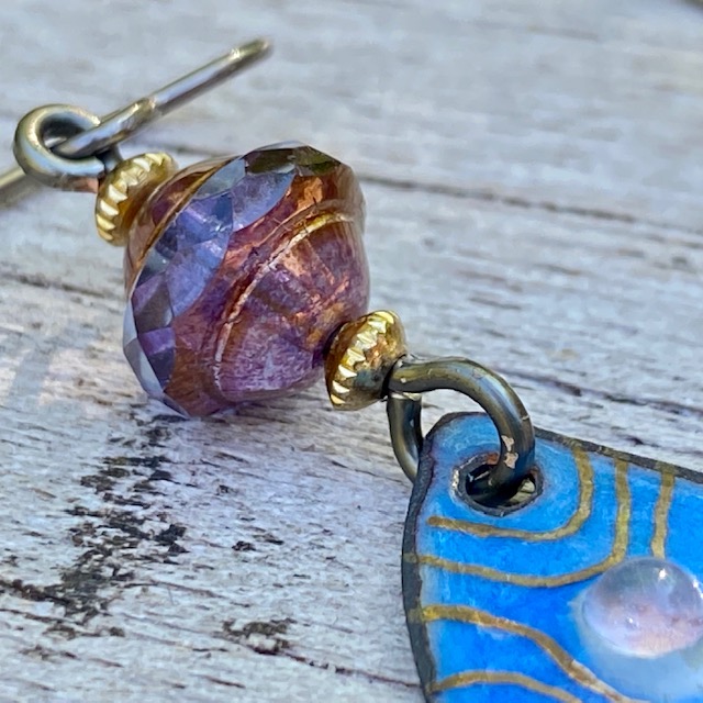 Boucles d'oreilles composées de pendentifs artisanaux en laiton émaillé et de perles en verre de Bohême. Crochets d'oreilles en niobium. Pièces uniques.