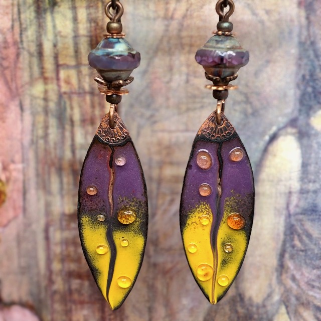 Boucles d'oreilles bohème chic et asymétriques, composées de pendentifs en cuivre émaillé en forme de plume mauve et jaune. Bijoux uniques.