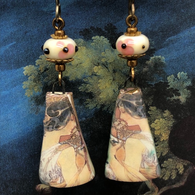 Boucles d’oreilles composées de pendentifs en céramique qui reprennent la lithographie de Mucha intitulée La primevère. Bijoux uniques.