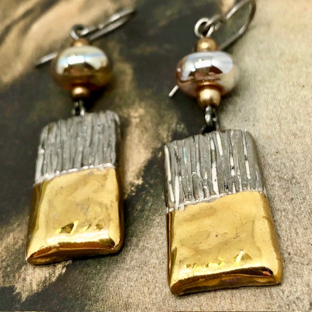 Boucles d'oreilles asymétriques et glamour composées de perles et de pendentifs en céramique or et platinum. Bijoux uniques de créateur.