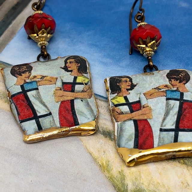 Boucles d’oreilles bohème chic composées de pendentifs artisanaux en céramique représentant deux femmes en robe Mondrian. Pièces uniques.