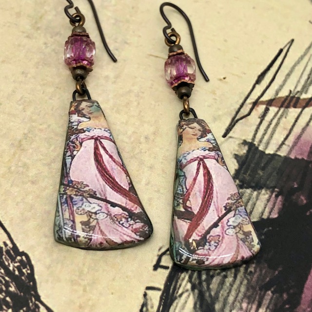 Boucles d’oreilles Art nouveau composées de pendentifs artisanaux en céramique représentant une jeune fille en robe rose. Pièces uniques.