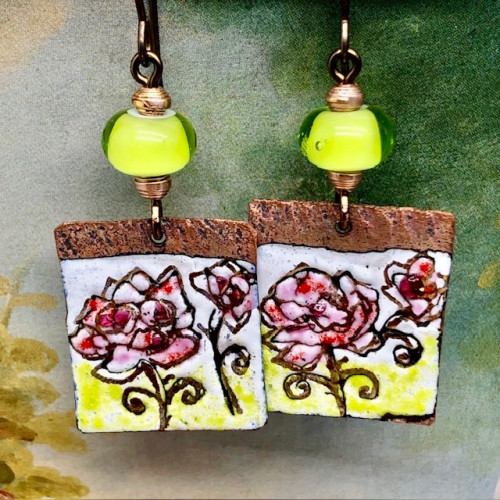 Boucles d'oreilles asymétriques et bohèmes composées de pendentifs en cuivre émaillé avec un motif de rose. Bijoux uniques de créateur.