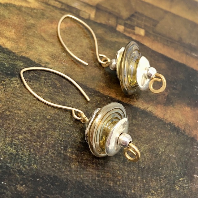 Boucles d'oreilles or et argent composées de perles disques en verre filé à la flamme et de perles en céramique.