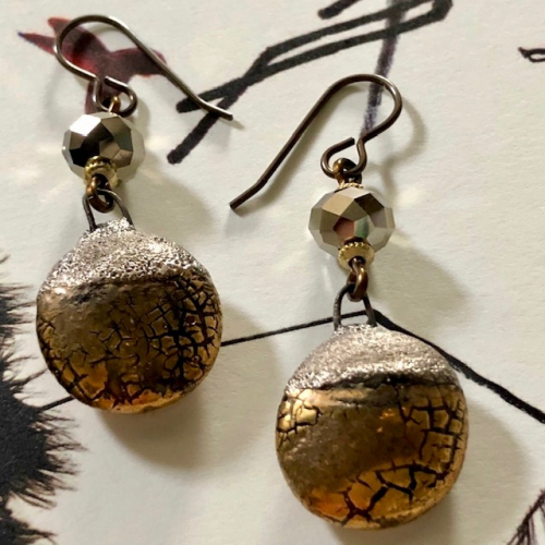 Boucles d'oreilles composées de pendentifs artisanaux en céramique or et de perles facettées en cristal Swarovski. Crochets d'oreilles en laiton.