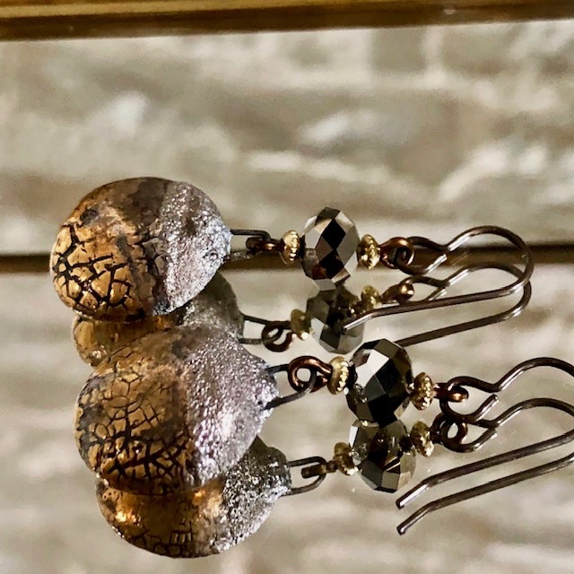 Boucles d'oreilles composées de pendentifs artisanaux en céramique or et de perles facettées en cristal Swarovski. Crochets d'oreilles en laiton.