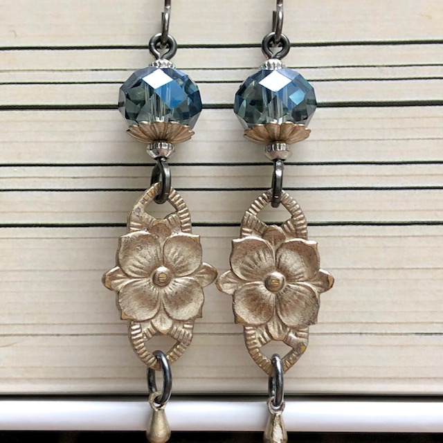 Boucles d'oreilles composées de jolies perles en cristal bleues et de fleurs en laiton argentées. Crochets d'oreilles en niobium.