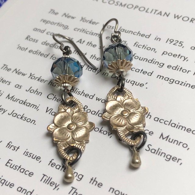 Boucles d'oreilles composées de jolies perles en cristal bleues et de fleurs en laiton argentées. Crochets d'oreilles en niobium.