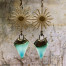 Boucles d'oreilles bohèmes composées de cônes en céramique bronze turquoise et de connecteurs en forme de soleil. Bijoux uniques de créateur.