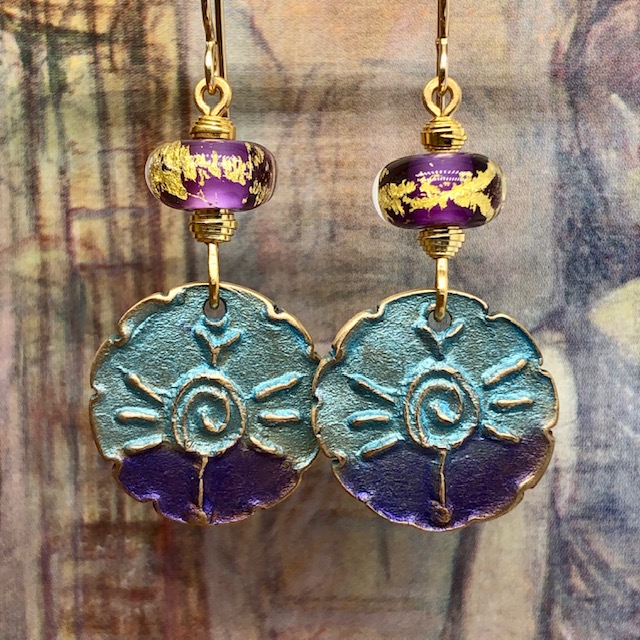 Boucles d'oreilles spirales, composées de pendentifs en bronze mauve et turquoise et de perles lampwork mauves incrustées d'or. Pièces uniques.