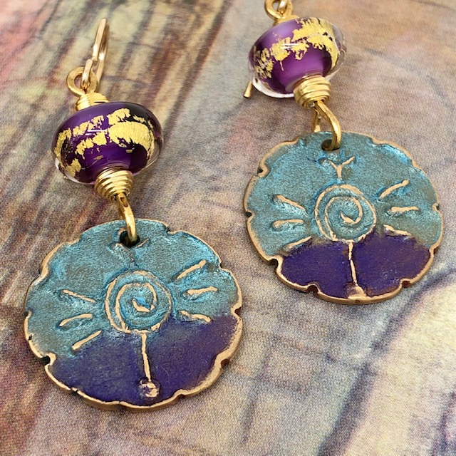 Boucles d'oreilles spirales, composées de pendentifs en bronze mauve et turquoise et de perles lampwork mauves incrustées d'or. Pièces uniques.