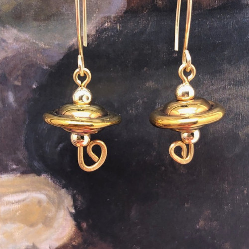 Boucles d'oreilles asymétriques composées de perles disques ondulés en verre filé à la flamme bronze or. Bijoux uniques de créateur.