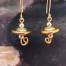 Boucles d'oreilles asymétriques composées de perles disques ondulés en verre filé à la flamme bronze or. Bijoux uniques de créateur.