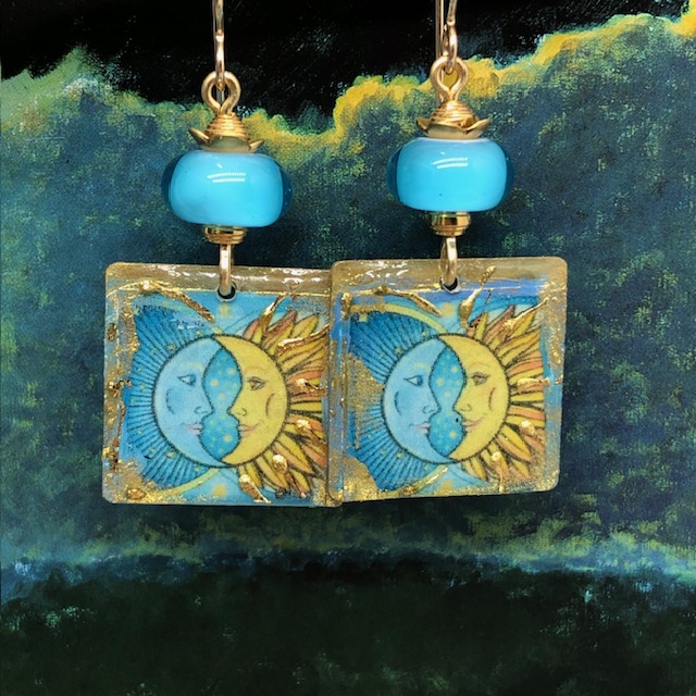 Boucles d'oreilles bohème chic composées de pendentifs artisanaux en résine bleu et jaune représentant le visage de la lune et du soleil. Bijoux uniques.