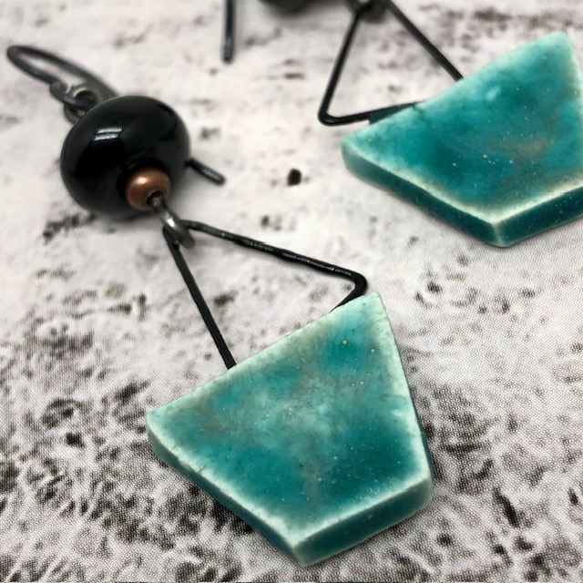 Boucles d'oreilles de créateur composées de pendentifs en céramique turquoise et noir, avec une forme de voilier. Bijoux uniques.