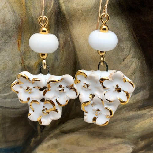 Boucles d’oreilles bohèmes composées de pendentifs en céramique qui représentent un bouquet de fleurs blanches et or. Bijoux uniques et poétiques.
