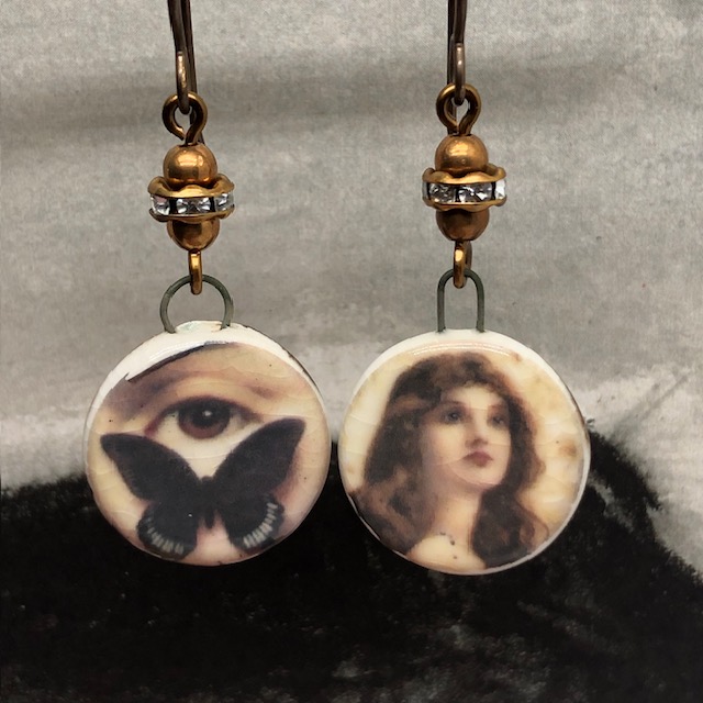 Boucles d'oreilles asymétriques composées de pendentifs sépia en céramique avec un papillon, un oeil et le portrait d'une femme. Bijoux uniques de créateur.