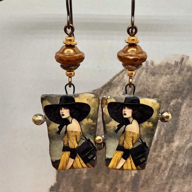 Boucles d’oreilles asymétriques composées de pendentifs en céramique avec le portrait d'une femme portant un chapeau noir. Bijoux uniques.