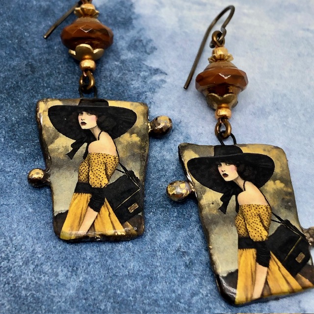 Boucles d’oreilles asymétriques composées de pendentifs en céramique avec le portrait d'une femme portant un chapeau noir. Bijoux uniques.