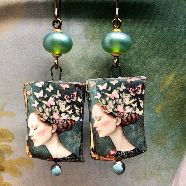 Boucles d’oreilles bohèmes asymétriques composées de pendentifs en céramique avec le portrait d'une femme entourée de papillons. Bijoux uniques.