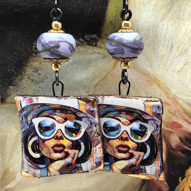 Boucles d’oreilles asymétriques pop art composées de pendentifs en céramique avec le portrait d'une femme, à la tenue estivale. Bijoux uniques.