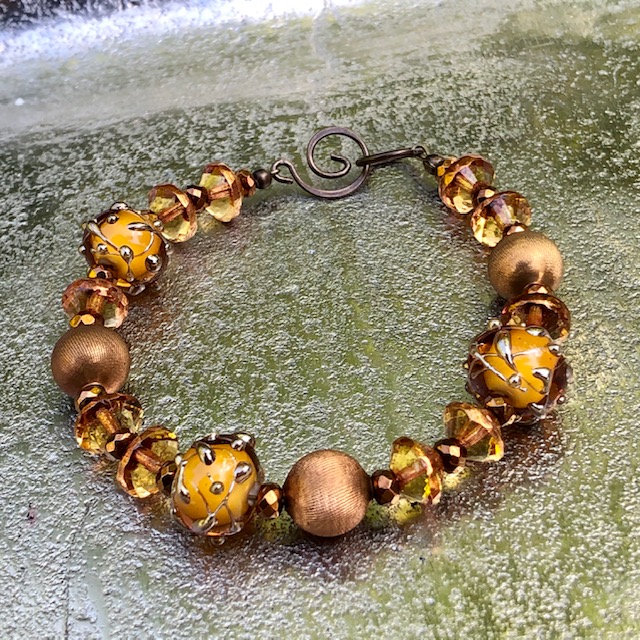 Bracelet composé de perles Lampwork, de perles en laiton et de perles en verre tchèque. Anneaux et fermoir en laiton. Pièce unique.