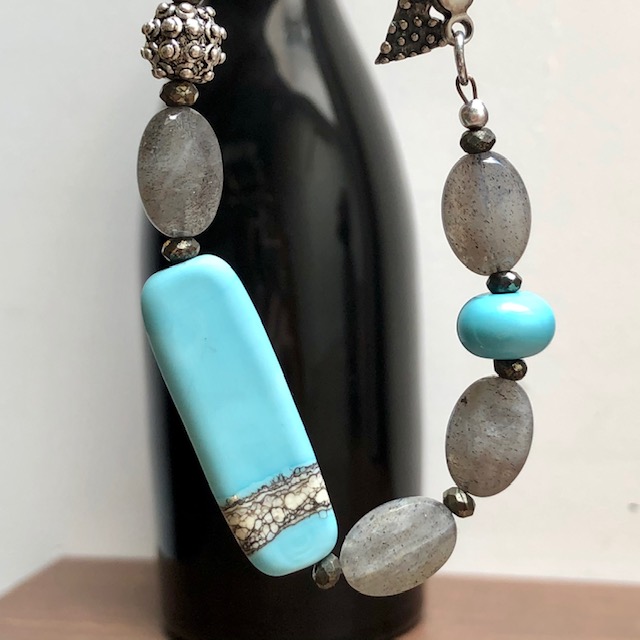 Bracelet composé de perles lampwork, de perles facettées en labradorite et de perles en argent Thaï Karen. Fermoir en argent. Pièce unique.