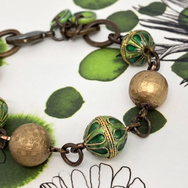 Bracelet vintage composé de perles rondes en cloisonné vertes et or et de perles en laiton doré. Pièce unique.