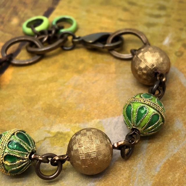 Bracelet vintage composé de perles rondes en cloisonné vertes et or et de perles en laiton doré. Pièce unique.