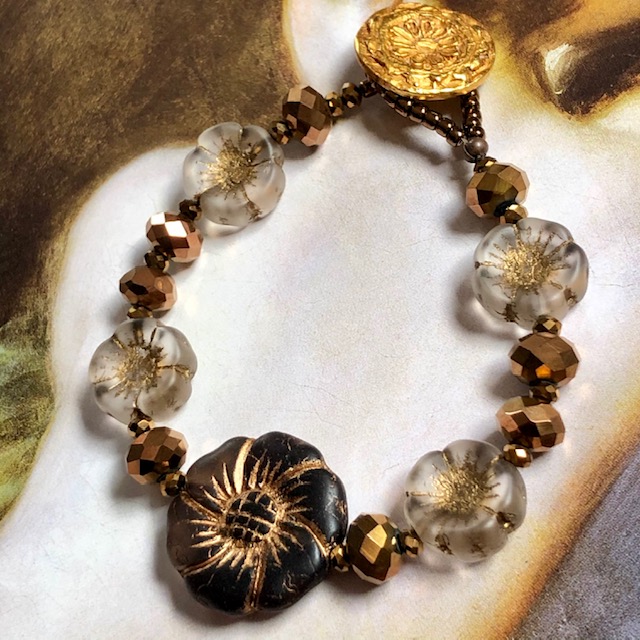 Bracelet floral composé de perles en verre tchèque, de perles de rocaille japonaises et d'un bouton en laiton doré.
