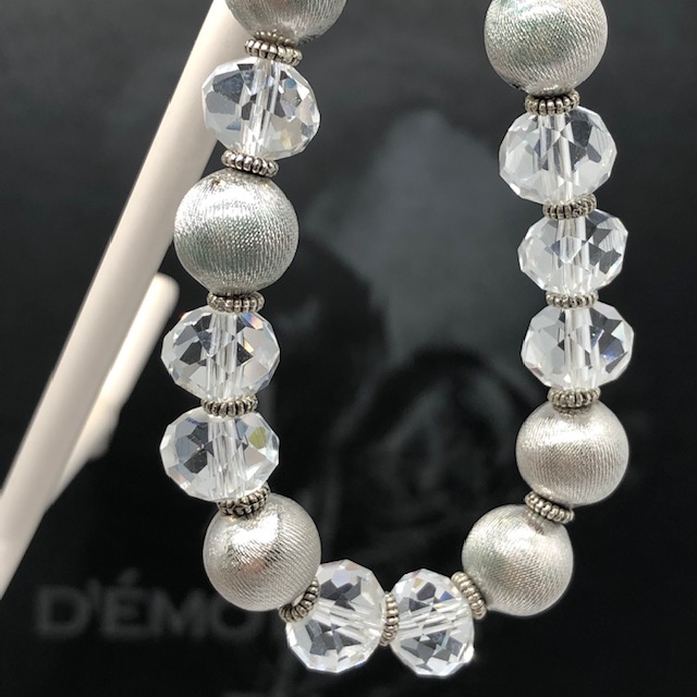 Ce bracelet lumineux est composé de jolies perles facettées en cristal et de perles en métal argenté. Fermoir et breloques en argent.