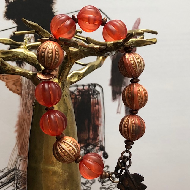 Bracelet composé de jolies perles en acrylique rose cuivré, orange brûlée et de différentes perles en cuivre. Pièce unique.