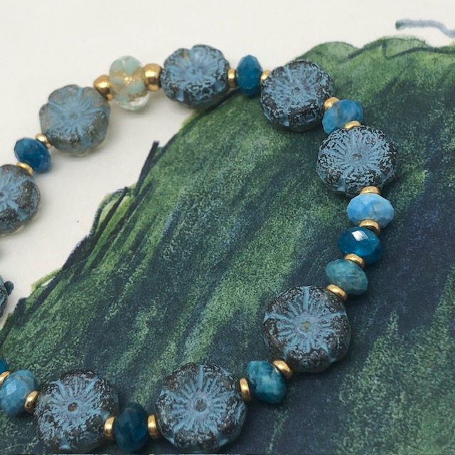 Bracelet élastique asymétrique, composé de perles en apatite et de perles en verre de Bohême bleu ciel en forme de fleur. Bracelet stretch de créateur.