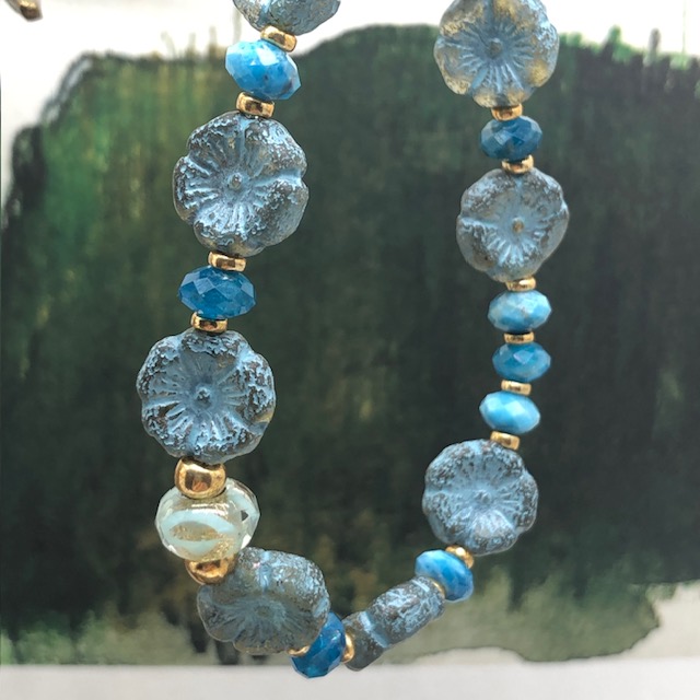 Bracelet élastique asymétrique, composé de perles en apatite et de perles en verre de Bohême bleu ciel en forme de fleur. Bracelet stretch de créateur.