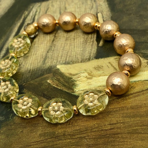 Bracelet élastique bohème chic composé de perles en verre de Bohême florales vert anis et de perles en laiton plaqué or. Bracelet stretch de créateur.