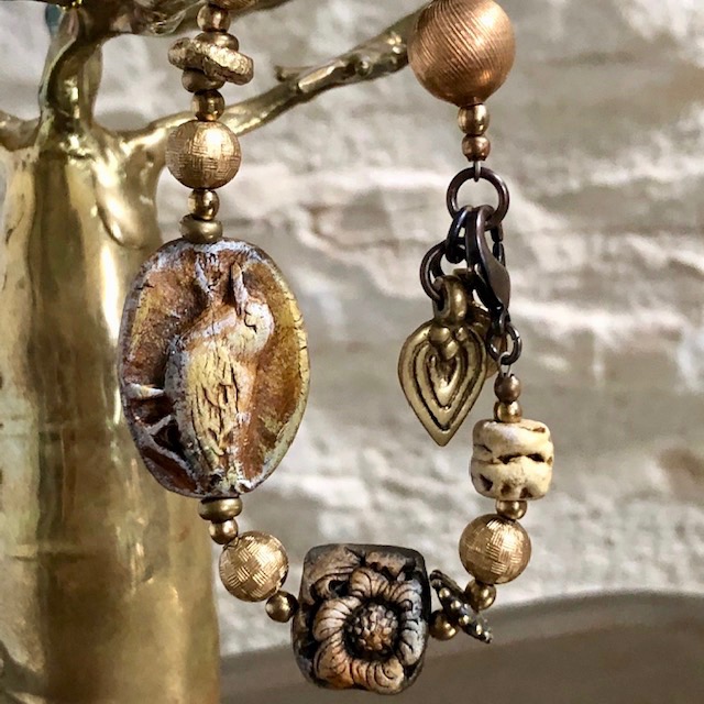 Bracelet composé de perles artisanales en céramique, de perles africaines en laiton et de perles vintage en lucite. Pièce unique.