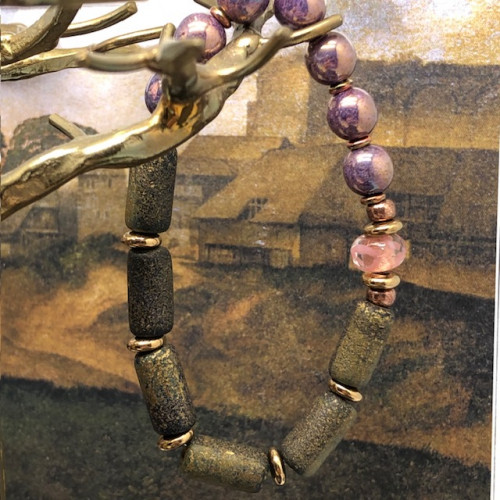 Bracelet élastique bohème chic composé de perles en verre de Bohême cylindriques kaki et de perles rondes mauve irisé.