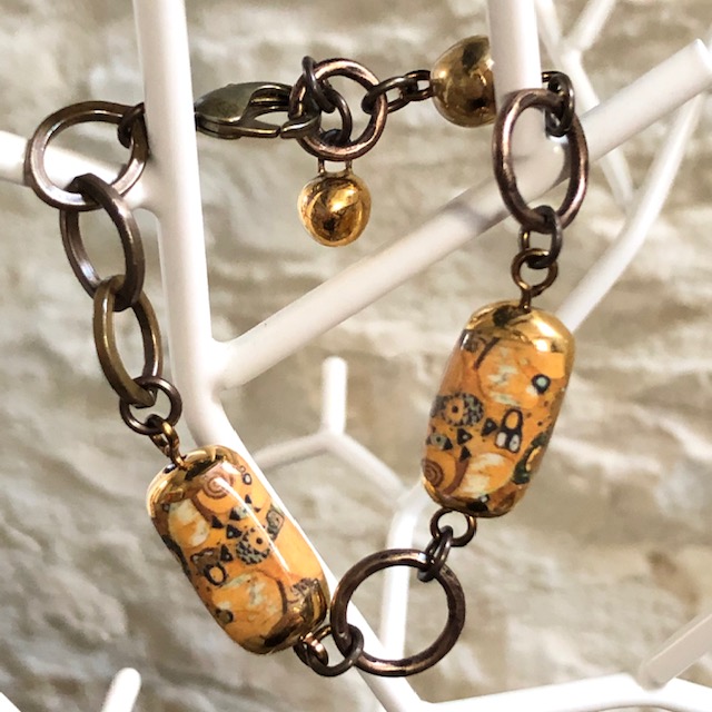Bracelet composé de perles artisanales en céramique figurant L'Arbre de Vie de Klimt. Anneaux et chaîne en laiton. Pièce unique.