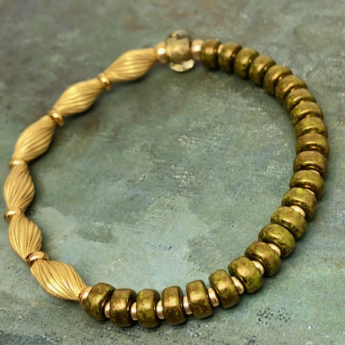 Bracelet élastique asymétrique, composé de perles laiton plaqué or et de perles en verre de Bohême vert kaki. Bracelet stretch de créateur.