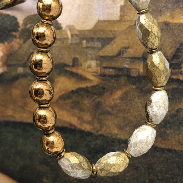 Bracelet asymétrique bohème chic stretch composé de perles en verre de Bohême dorées et bronze. Bracelet élastique de créateur.