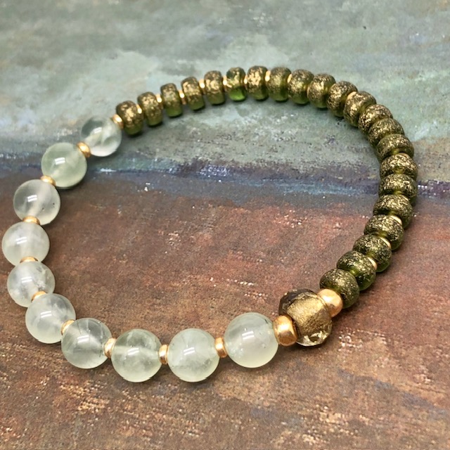 Bracelet élastique asymétrique, composé de perles en prehnite naturelle et de perles en verre de Bohême kaki. Bracelet stretch de créateur.