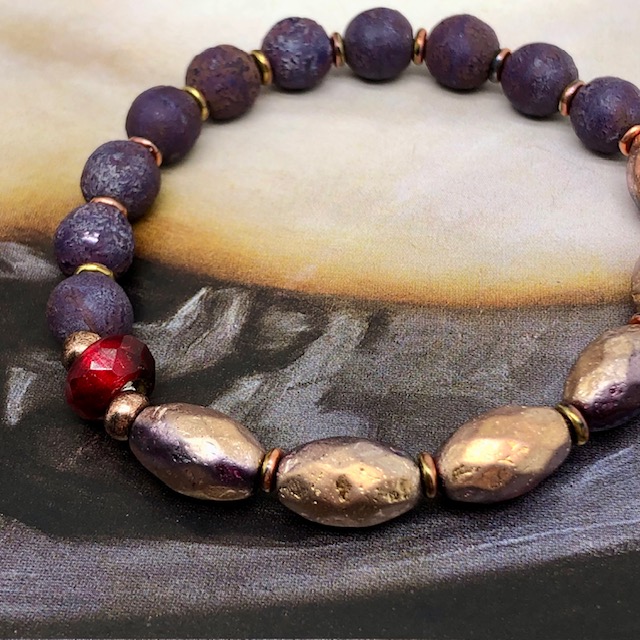 Bracelet élastique bohème chic, composé de perles en verre de Bohême ovales rose cuivré et de perles rondes violet foncé.