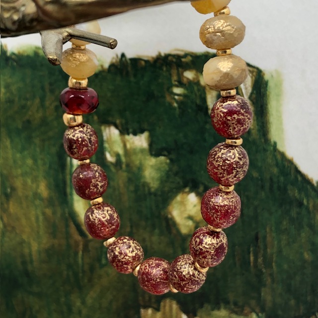 Bracelet élastique asymétrique bohème chic composé de perles en verre de Bohême rouge et jaune or. Bracelet stretch de créateur.