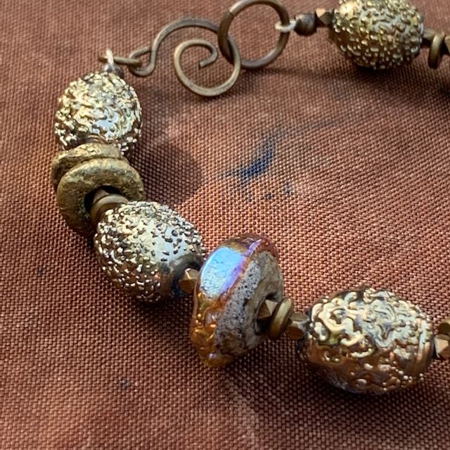 Bracelet aux couleurs du désert composé de perles Lampwork et de perles africaines en laiton. Fermoir en laiton. Pièce unique.