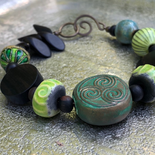 Bracelet composé de perles artisanales en céramique, de perles en bois d'ébène et de perles en cuivre émaillé. Fermoir en laiton. Pièce unique.