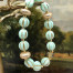 Bracelet élastique bohème chic composé de perles melon en verre de Bohême vert clair et de perles en laiton doré. Bracelet stretch de créateur.